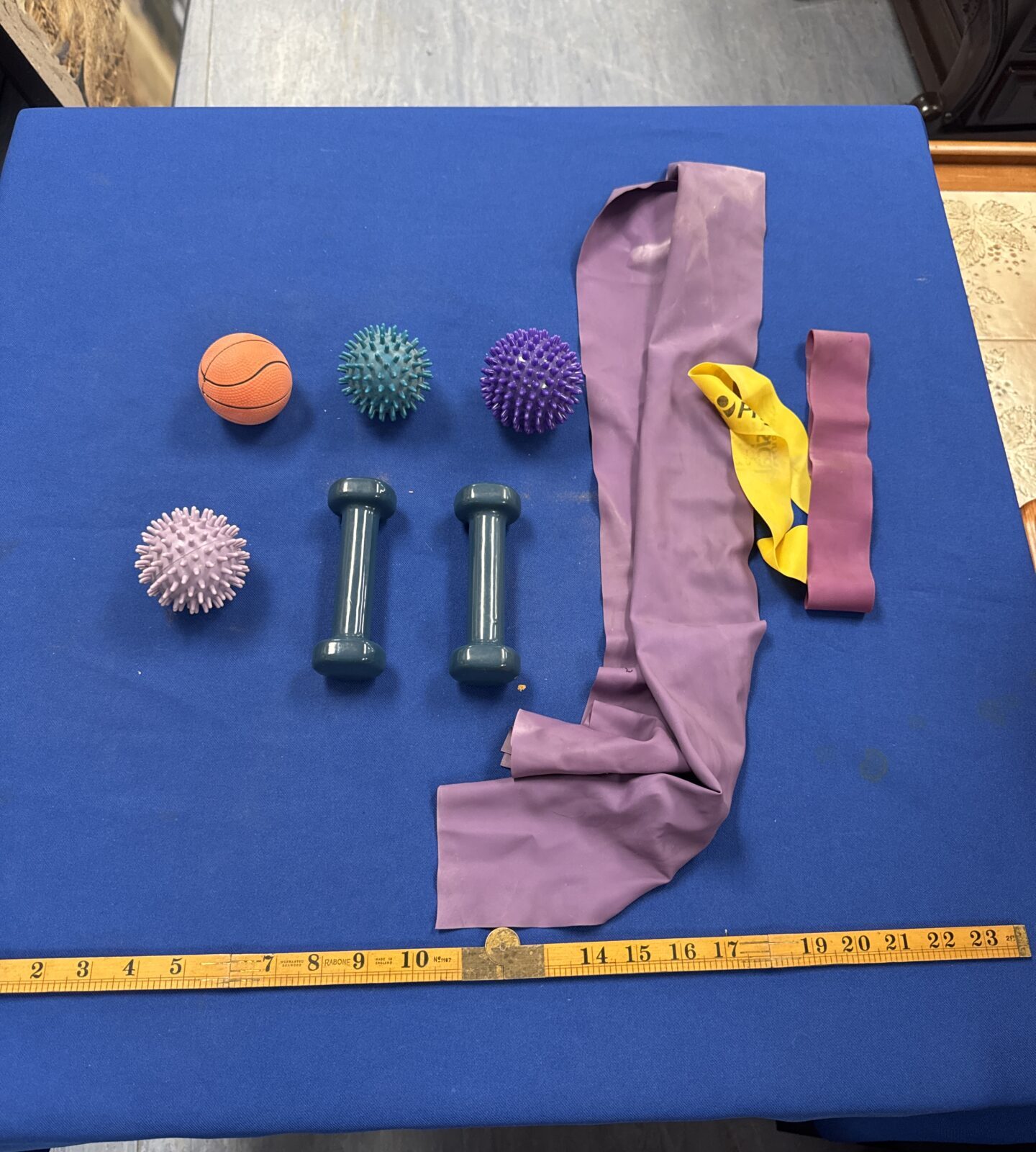 Fitness equipment lot including dumbbells, resistance bands and exercise ball.