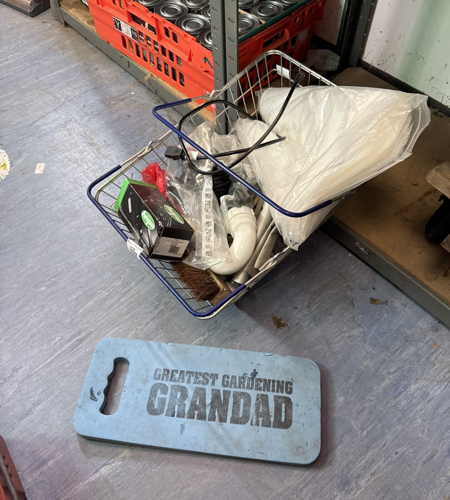 Garage clearance lot with bike parts and dust sheets.