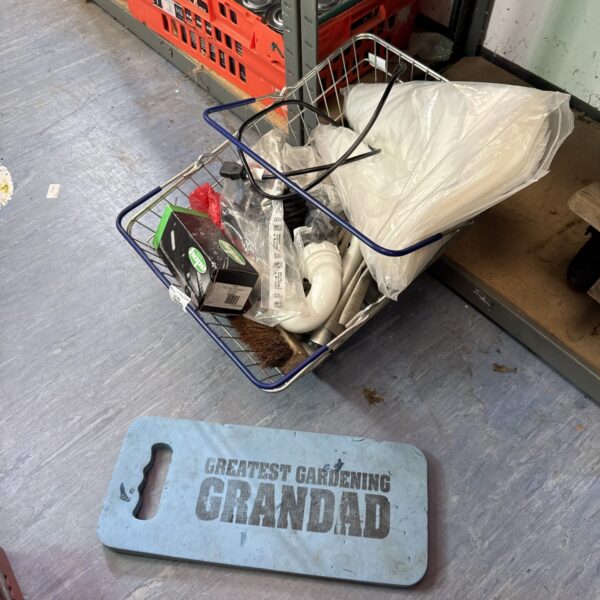 Garage clearance lot with bike parts and dust sheets.