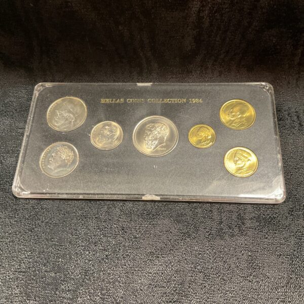 Front view of the 1984 Hellas coin collection in a clear case.