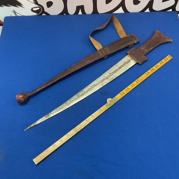 Authentic Nigerian tribal sword with wavy blade and dark handle.