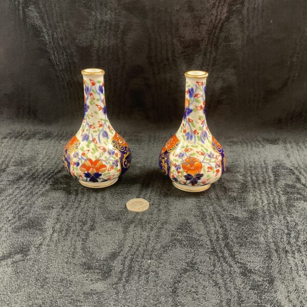 Pair of antique Crown Derby posy vases with colourful floral patterns.