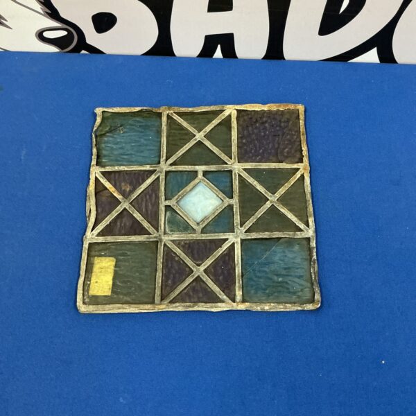 Antique leaded glass window pane with geometric design.