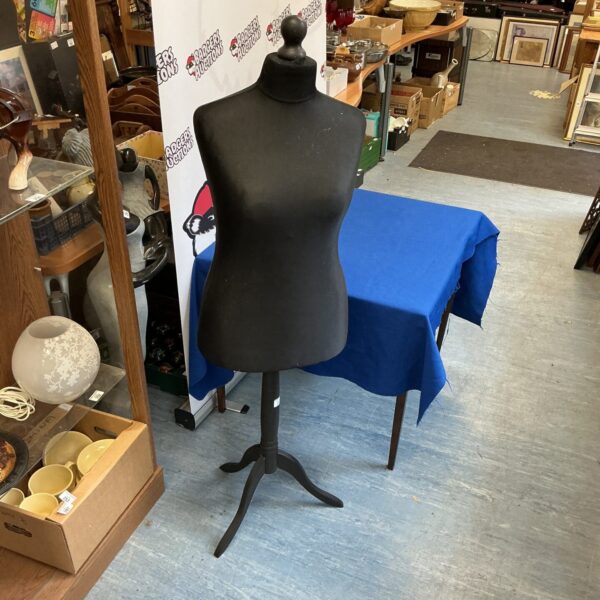 Vintage dressmaker manikin with dark fabric covering and tripod base.