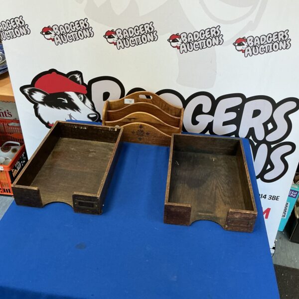 Antique wooden paper trays and letter rack on a desk.