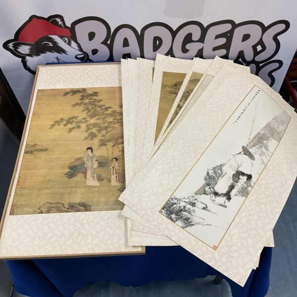 Vintage Chinese scroll prints in a cartoned collection, showcasing scenic artwork.