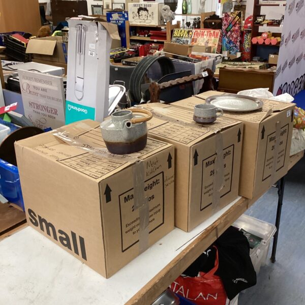 Boxes of vintage tableware including plates and a teapot.