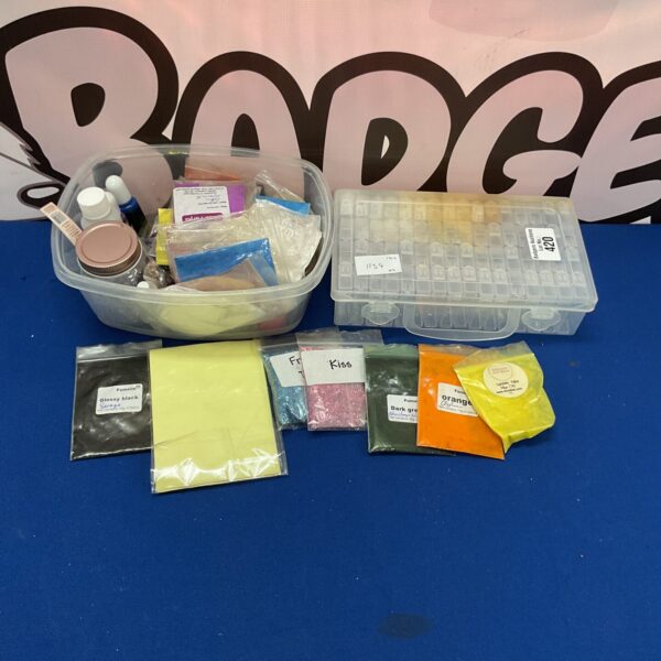Mixed lot of fabric dyes and crafting supplies in a storage box.