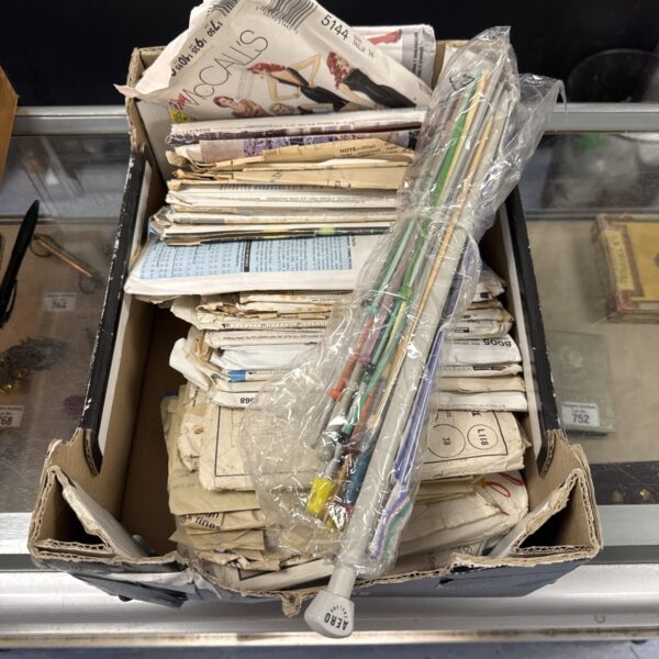 Vintage sewing and knitting patterns in a bundled lot.
