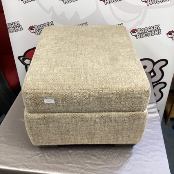 Neutral upholstered storage footstool with lift-top for hidden storage.