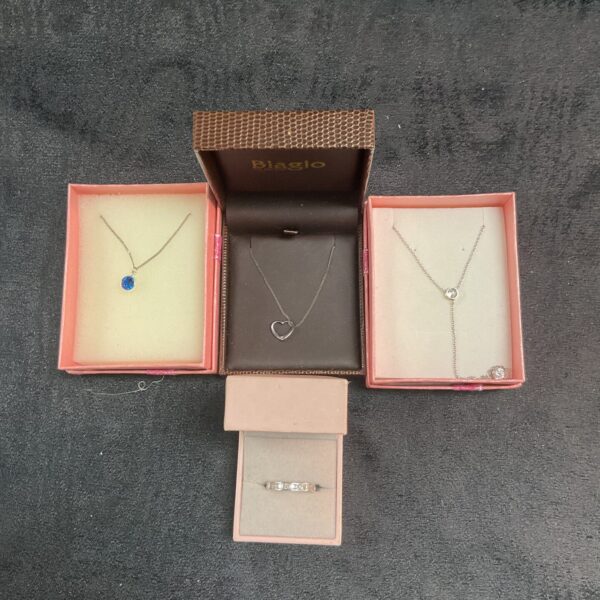 Silver pendant necklace set and ring displayed in a box.