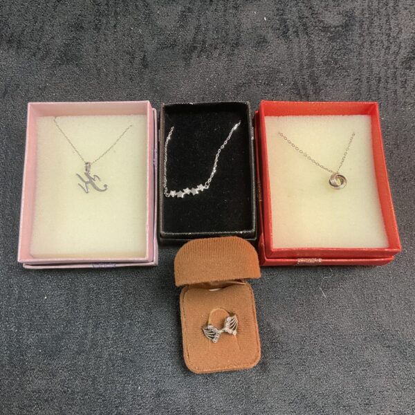 Silver pendant necklace set and ring on display.