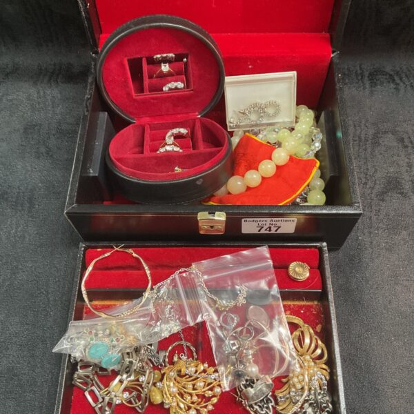 Open jewellery box displaying a colourful assortment of costume jewellery.