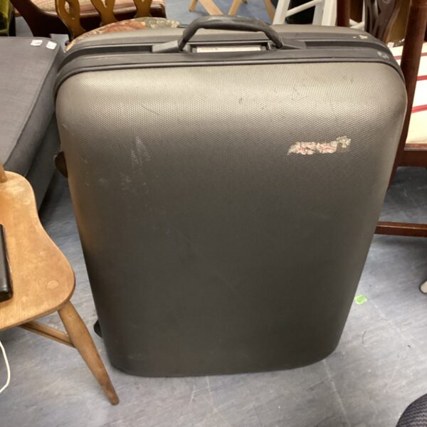 Black Samsonite rolling suitcase with extendable handle and wheels.