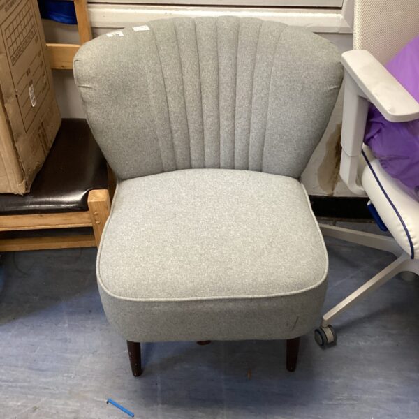 Neutral upholstered shell back bedroom chair with wooden legs.