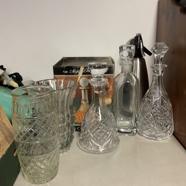 Elegant cut glass decanters and vases displayed as a vintage glassware collection.
