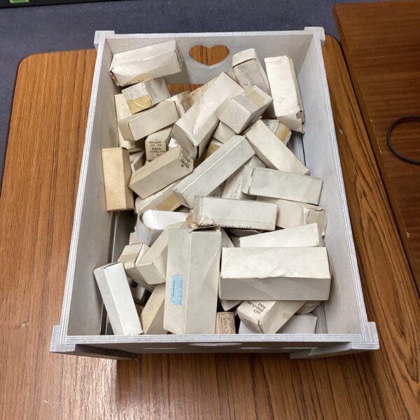 Vintage military valve components in a wooden basket.