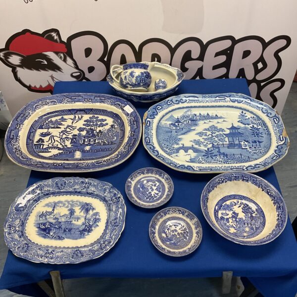 Vintage blue willow pattern ceramics collection including plates and bowls.