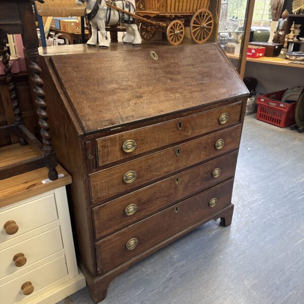 Front view of a handsome Georgian oak bureau with four drawers.