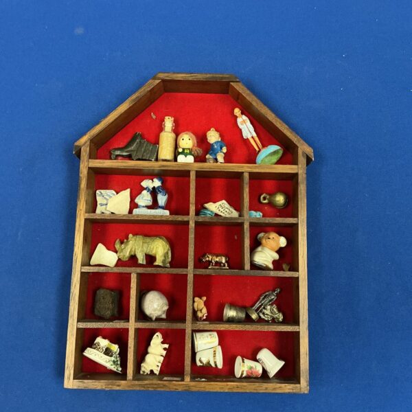 Vintage miniature shelf display with assorted collectibles.