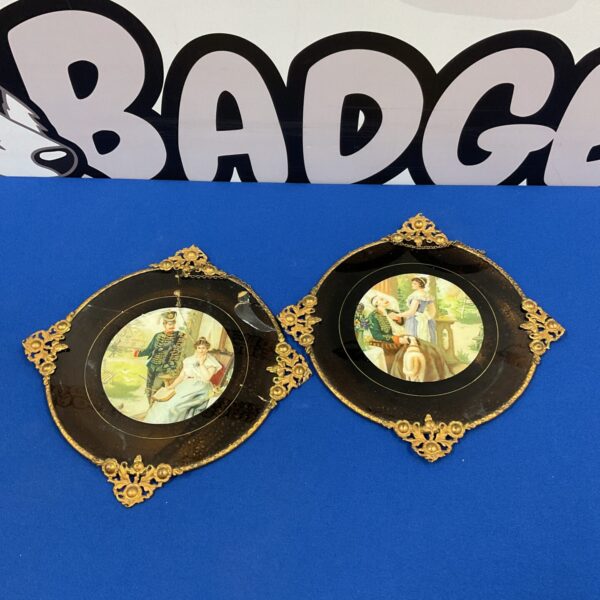 Vintage brass framed prints depicting classical scenes on glass.