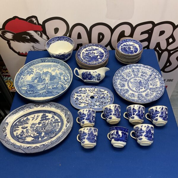 Vintage blue and white willow pattern china collection on display.