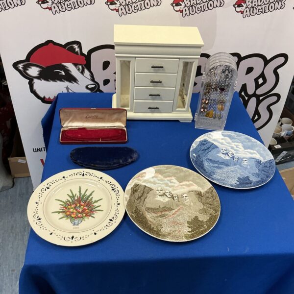 Vintage jewellery chest with collectible plates on display.