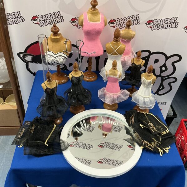 Miniature jewellery display mannequins on a mirrored base.