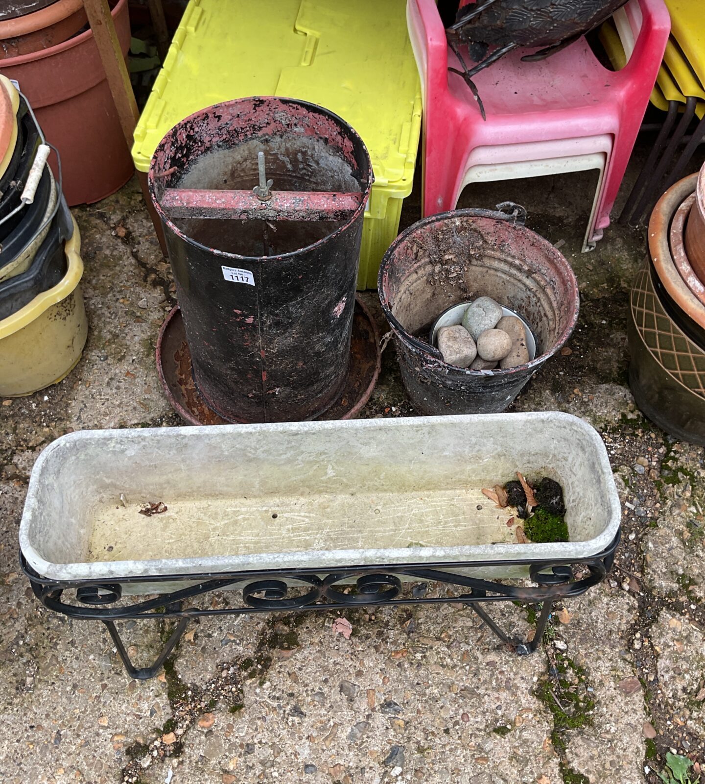 A vintage chicken feeder with galvanised bucket and trough planeter