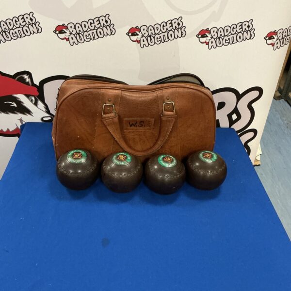 Vintage lawn bowls set with brown leather carry case.