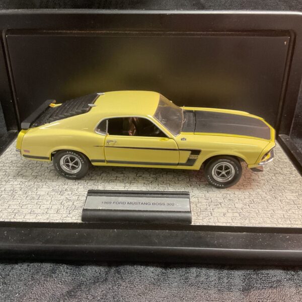 Yellow Franklin Mint 1969 Mustang Boss 302 diecast model car.