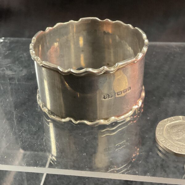 Hallmarked silver napkin ring, classic table setting accessory.
