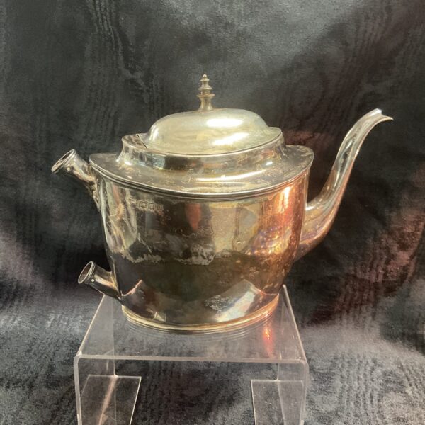 Front view of antique silver teapot with hallmarked silver.