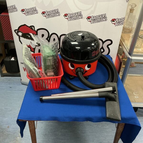 Red Numatic Henry vacuum cleaner with attachments for sale.