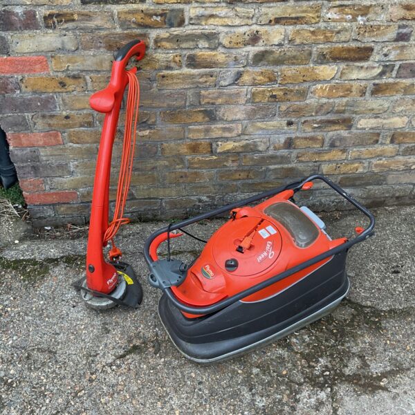 Red Flymo Vision Compact 330 electric lawnmower for garden maintenance.