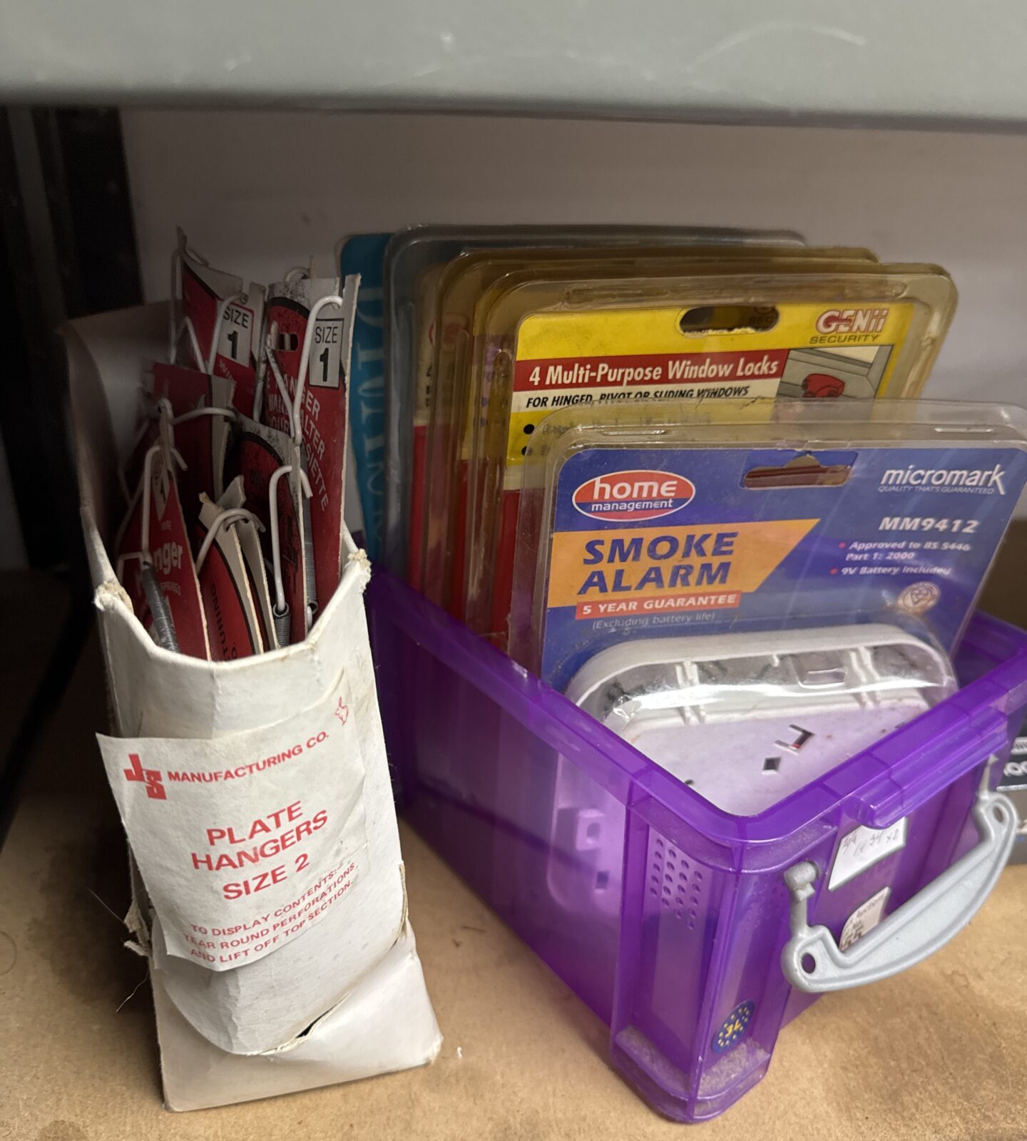 Tub of smoke alarms & lock sets with box of decorative plate hangers