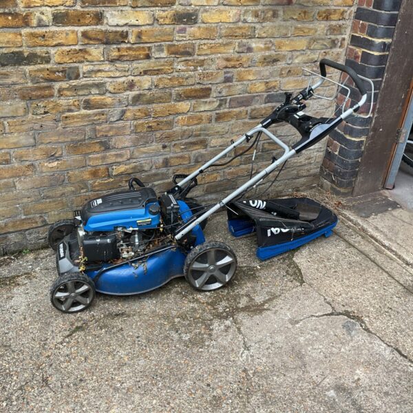 Hyundai 196cc petrol lawn mower in a garden setting.