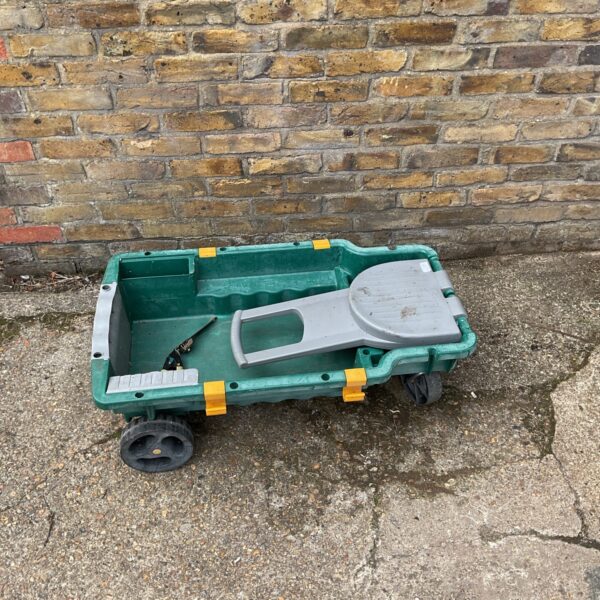 Green plastic garden trolley with wheels for outdoor use.