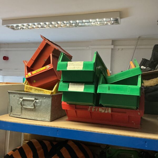 Colorful plastic workshop storage trays for tools and parts.