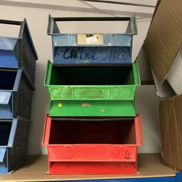 Three colourful metal workshop storage trays for tools.