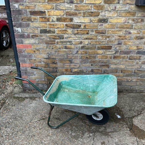 Green plastic garden wheelbarrow for moving garden materials.