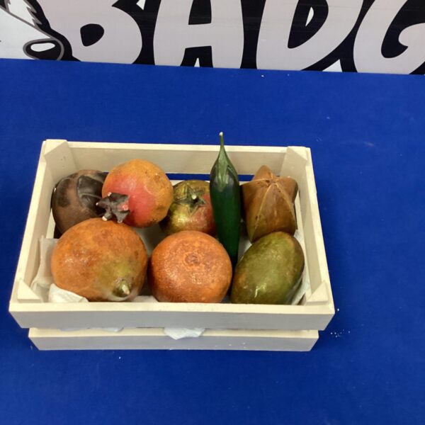 Vintage carved wooden fruits displayed in a small wooden crate.