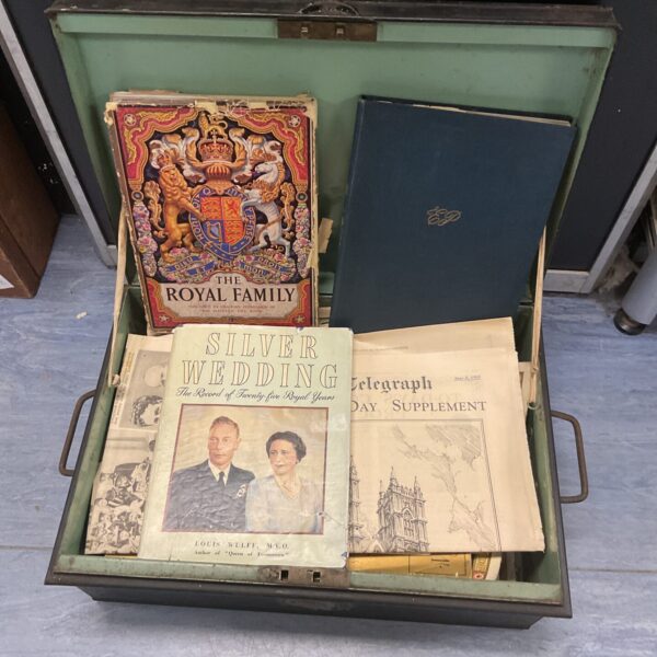 Vintage tin deed box filled with royal memorabilia and historical papers.