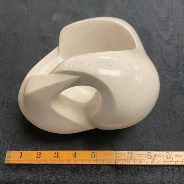 Abstract stone dove sculpture on a dark surface.