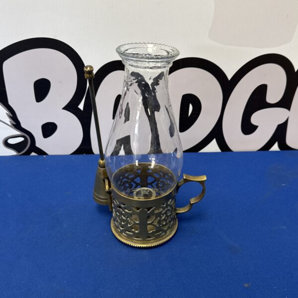 Vintage brass candle lantern with snuffer on a dark surface.