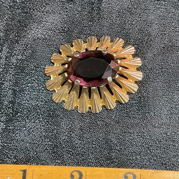 Vintage 1950s sunburst brooch with amethyst coloured stone.