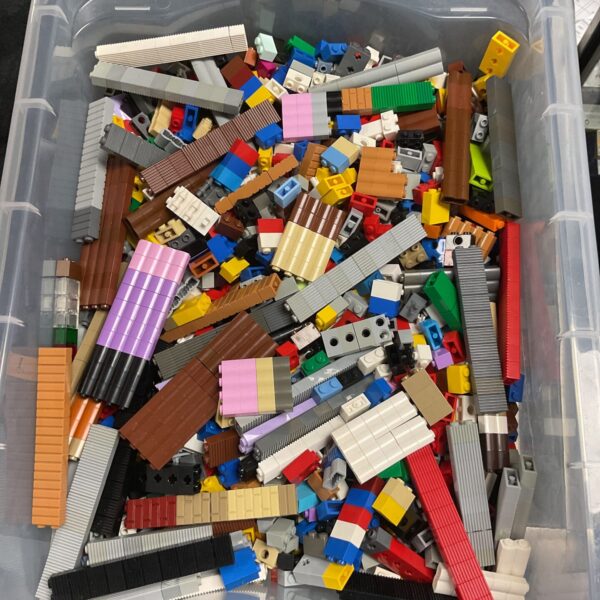 Crate filled with assorted Lego bricks and building pieces.