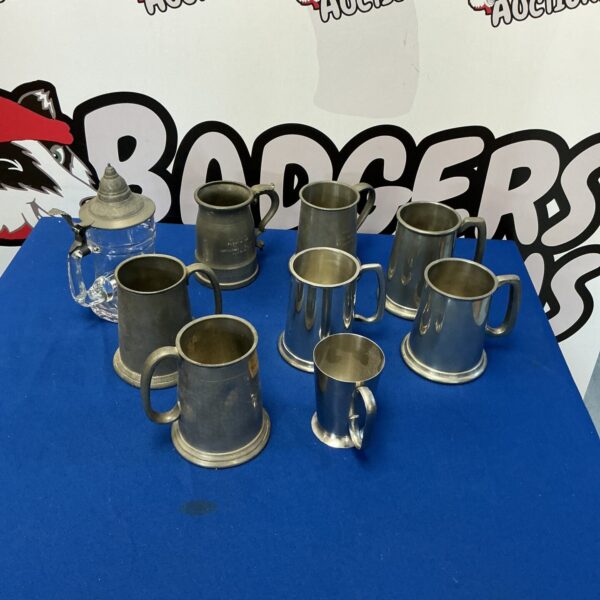 A lot of antique pewter tankards for collectors.