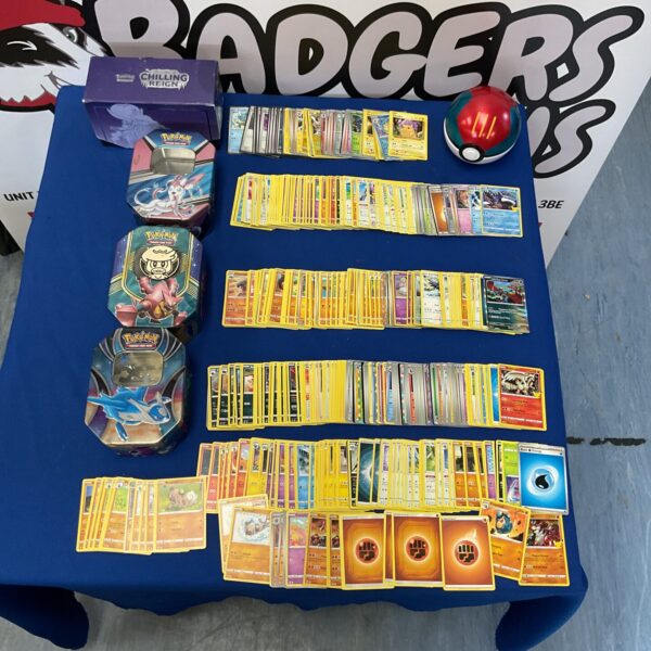 Large Pokemon card collection in tins with Charizard and Pikachu.