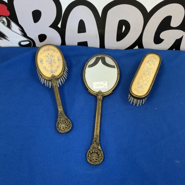 Ornate antique silver hand mirror with floral detailing.